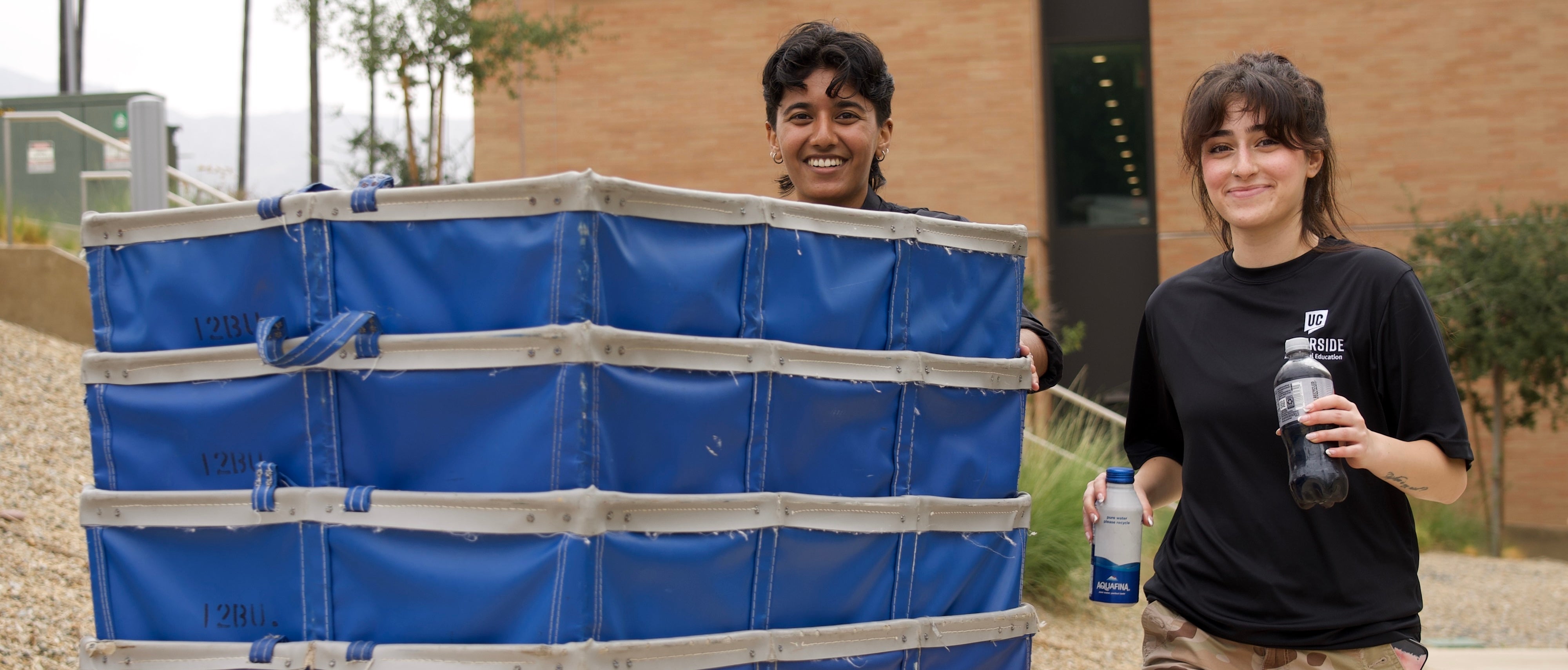 Housing Services student workers push blue move-in carts.