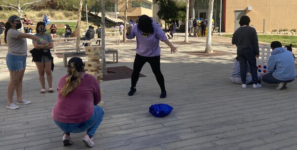 Students playing jenga outside