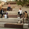 Students sit on steps outside the North District Campus Apartments.