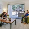 A parent teaches a child in the living room of a room at Oban Family Housing.