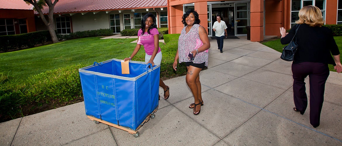 Student and parent with empty moving cart